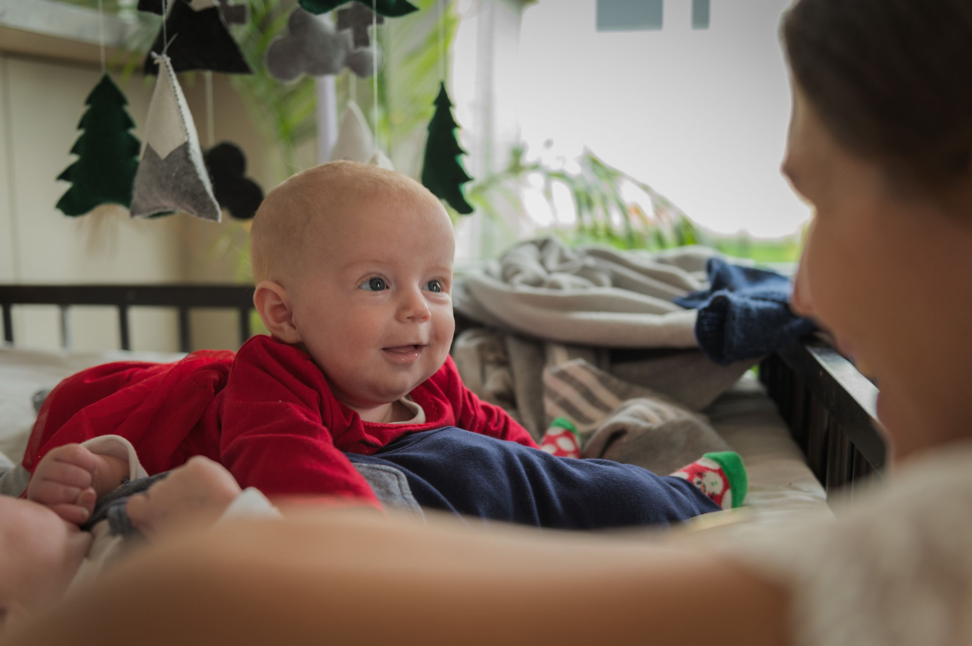 Eine Frau mit einem Baby im Kinderbett, voller Zuneigung und Wärme Eine Frau mit einem Baby im Kinderbett, voller Zuneigung und Wärme